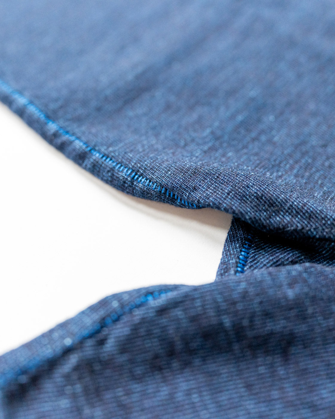 Close-up of blue denim fabric with a white background
