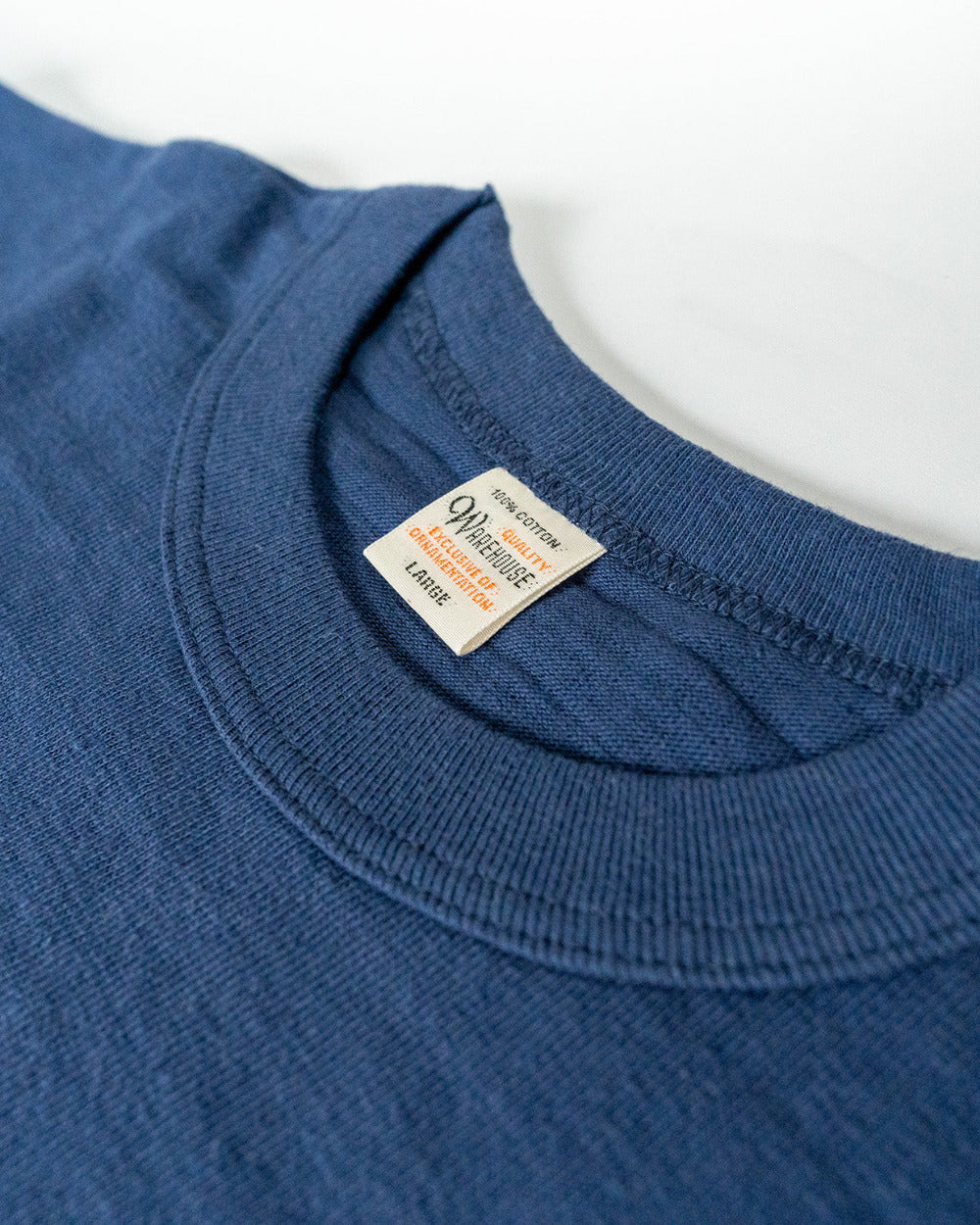 Close-up of a blue shirt with a brand label on a white background