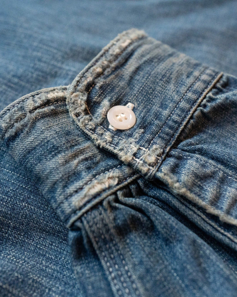 Close-up of a buttoned cuff of a blue denim shirt