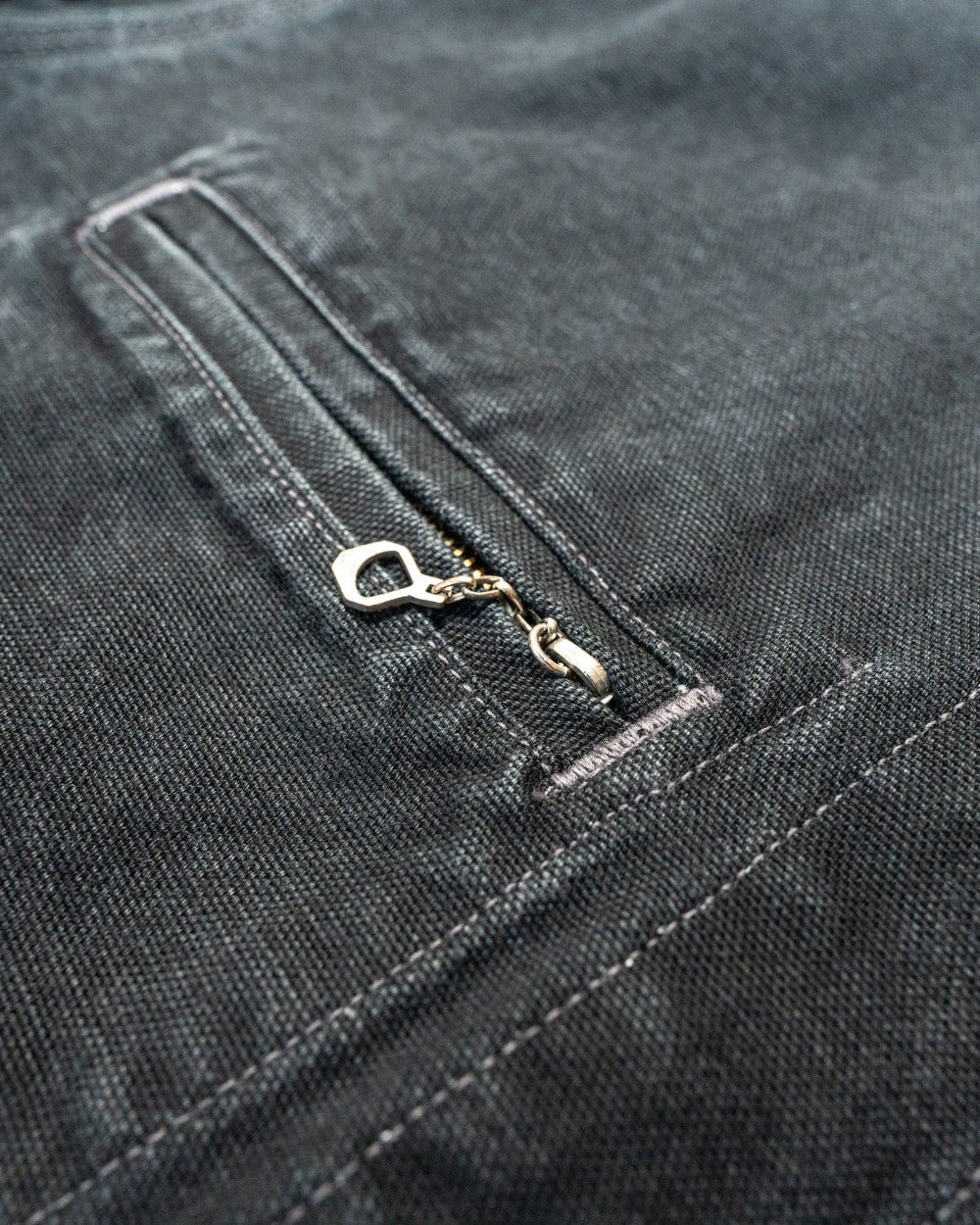 Close-up of a zipper on a dark denim background