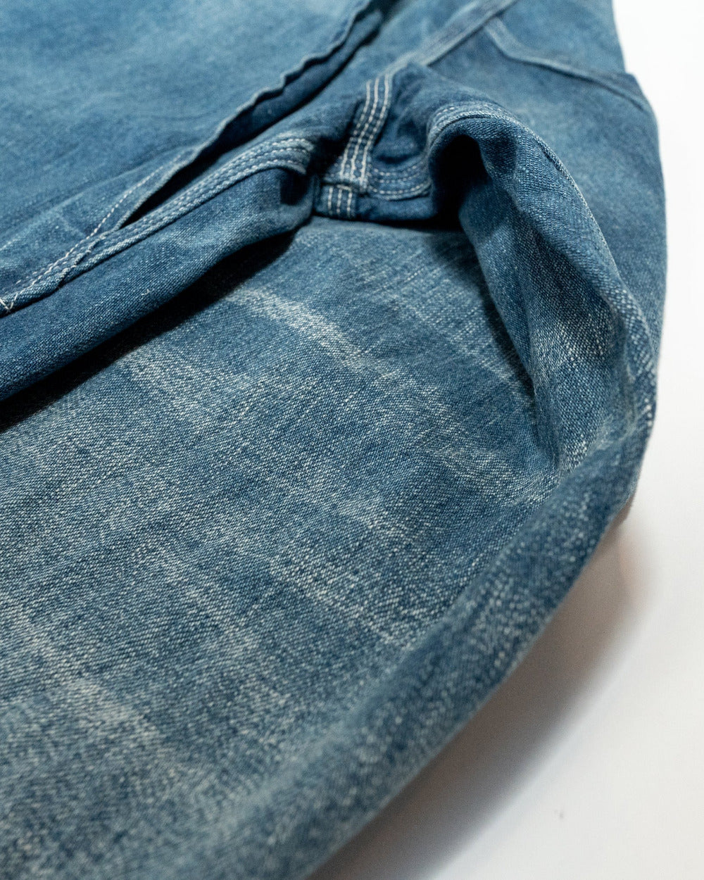 Close-up of blue denim fabric with a checkered pattern on a white background
