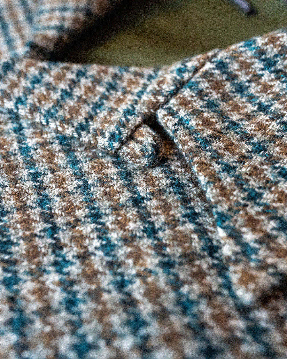 Close-up of a patterned fabric with brown, blue, and beige colors.