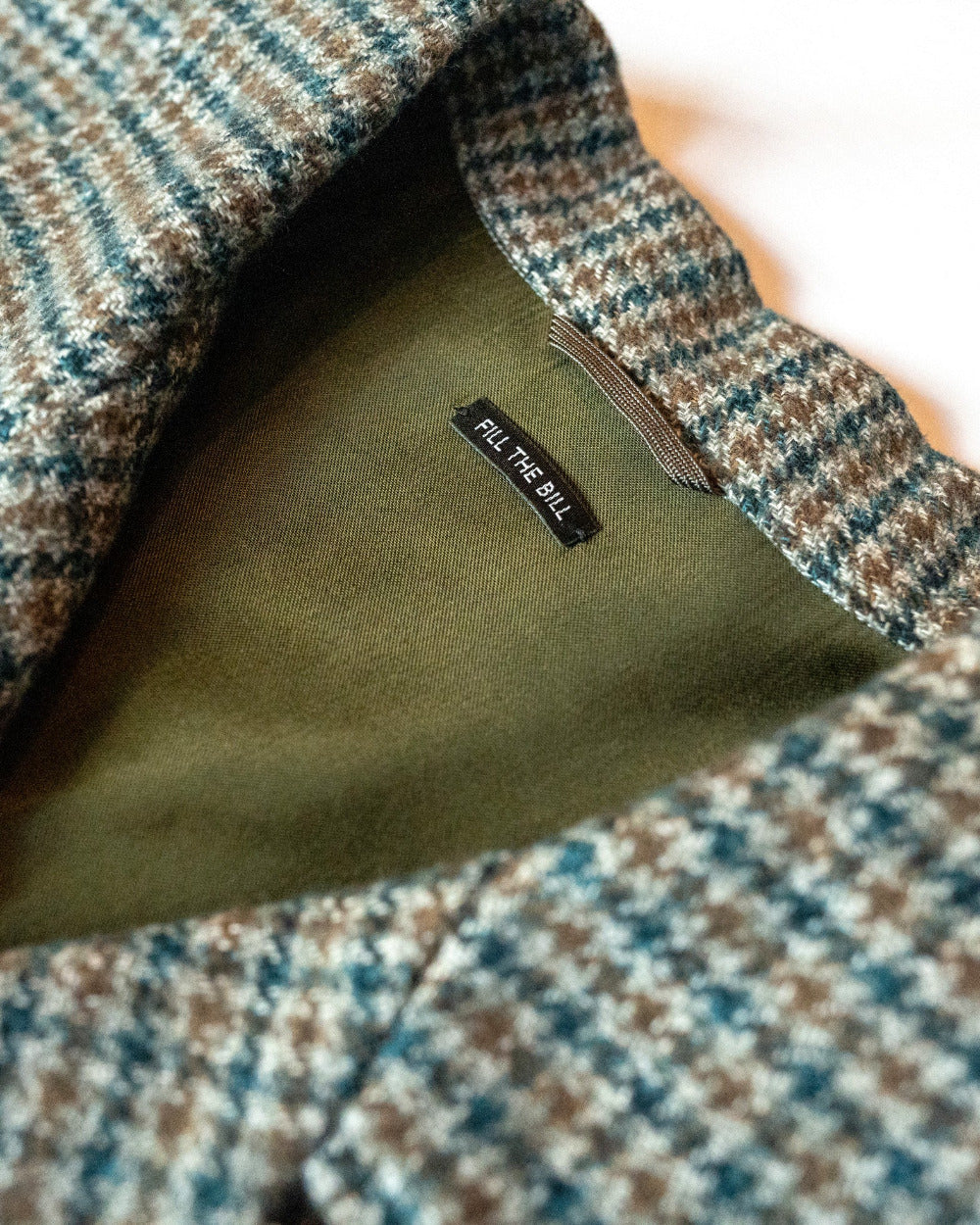 Close-up of a patterned fabric with a visible brand label on a white background