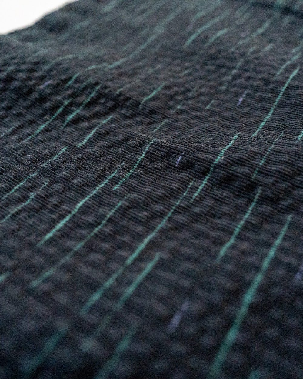 Close-up of textured navy fabric with green lines
