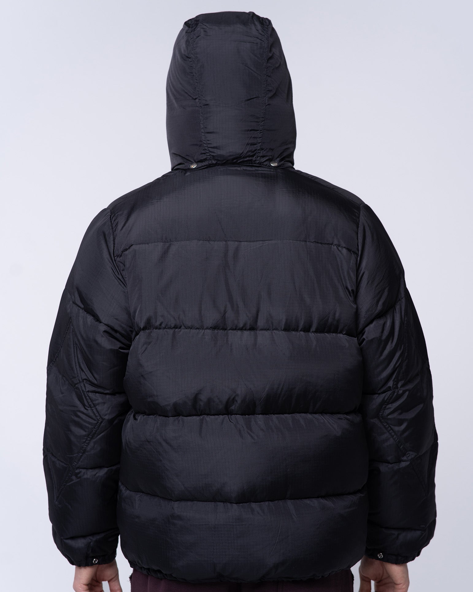 Black puffer jacket with a hood on a white background