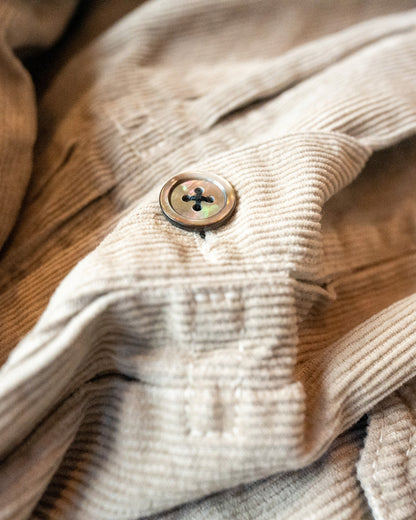 Close-up of a beige corduroy fabric with a button