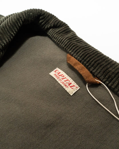 Close-up of a green jacket with a brand label on a white background