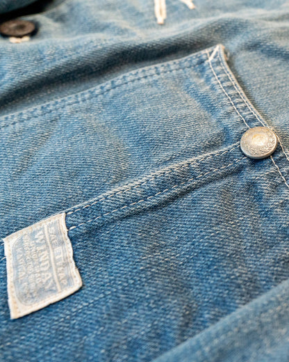 Close-up of a blue denim fabric with a button and label.