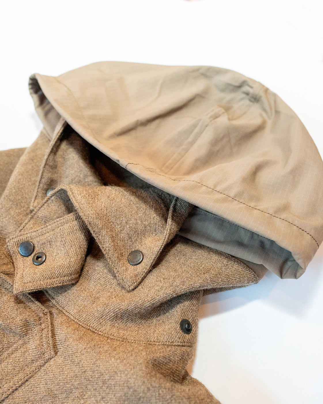 Close-up of a beige jacket with a hood on a white background