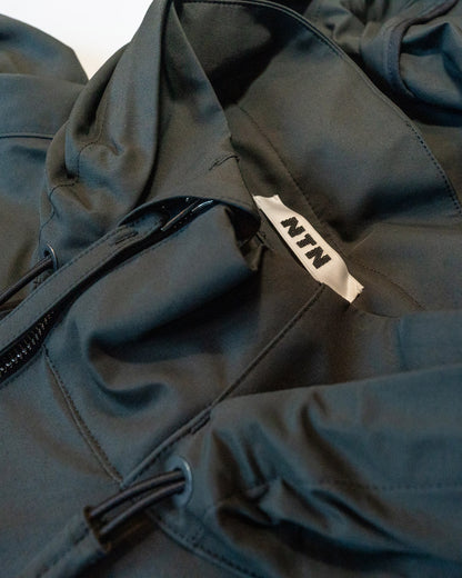 Close-up of a dark blue jacket with a brand logo on the chest pocket.
