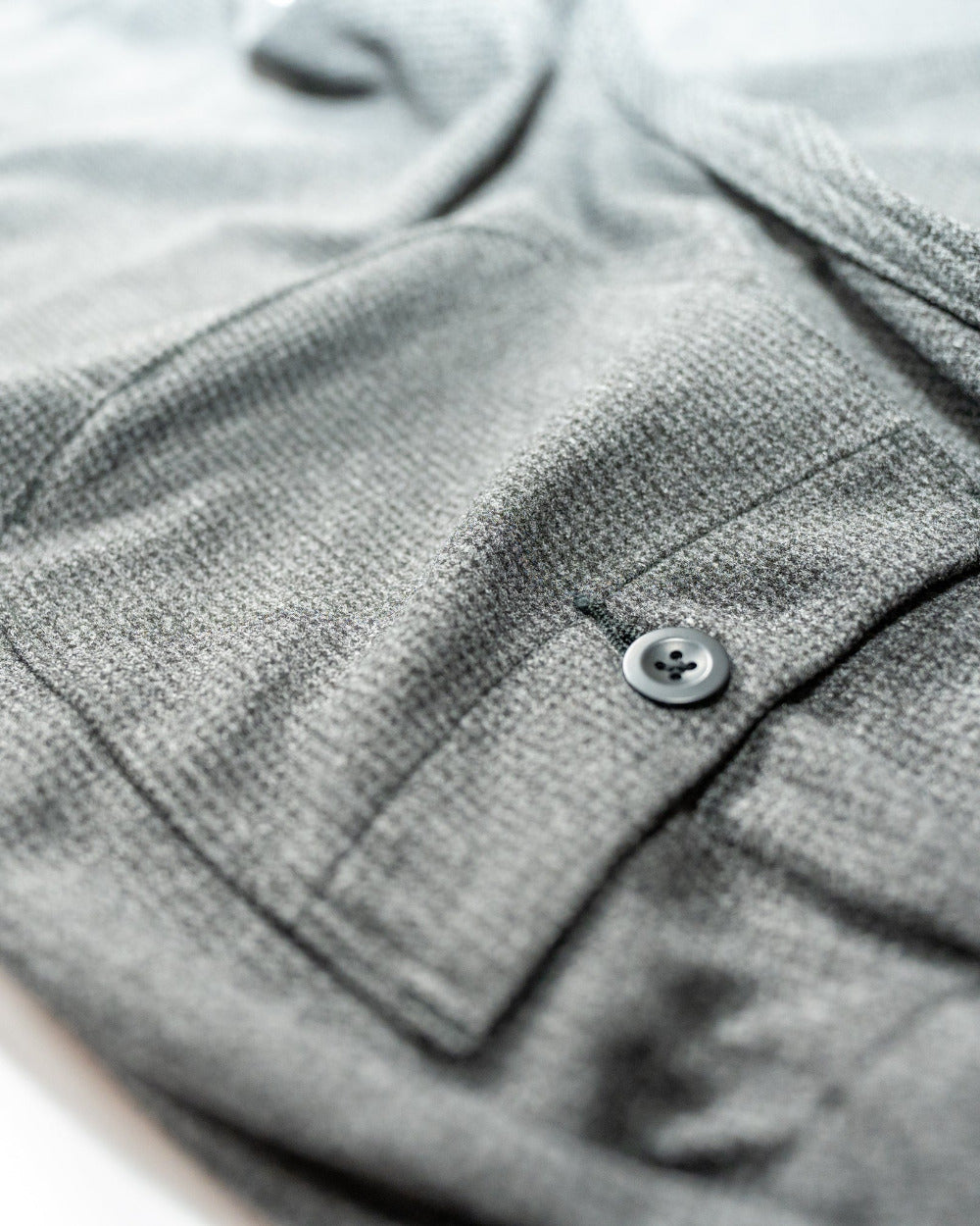 Close-up of a gray textured fabric with a button