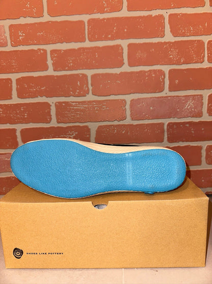 Blue shoe sole on a cardboard box with a brick wall background